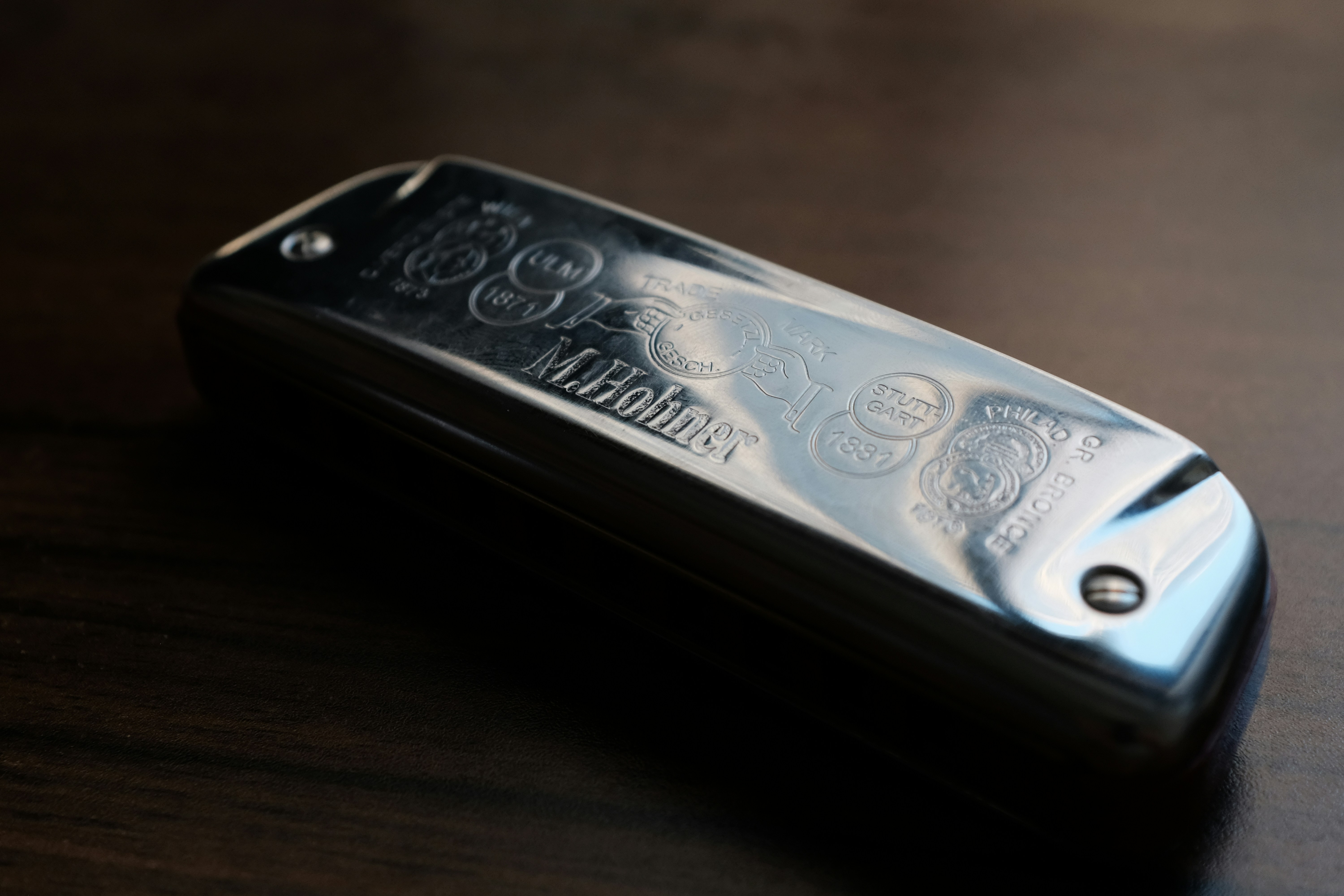 Silver 10-hole diatonic harmonica on a wooden table